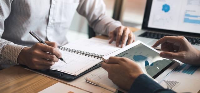 Two business partnership coworkers discussing a financial planning graph and company during a budget meeting in office room